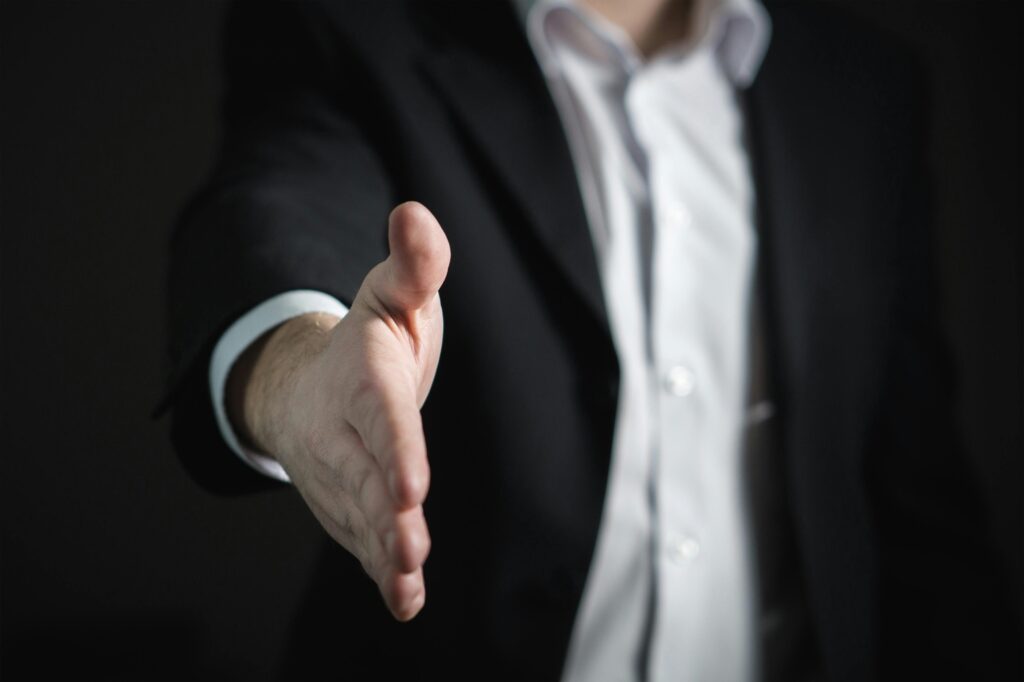 Mano extendida para cerrar un acuerdo empresarial, negociación y contratación de talento